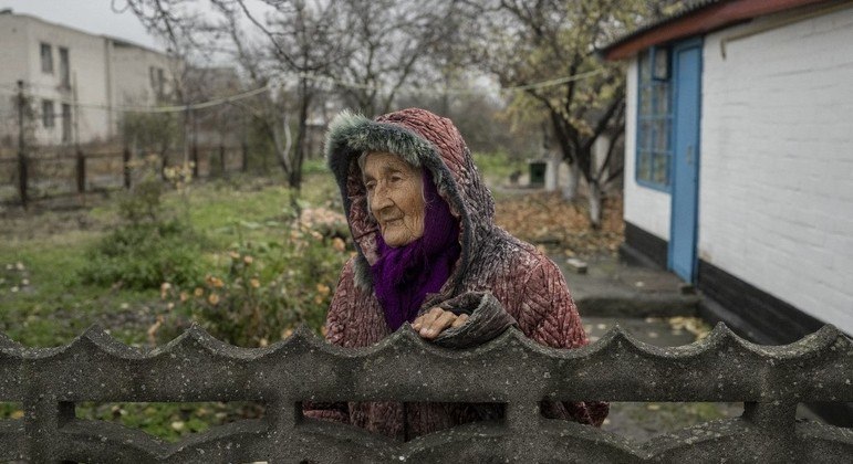 Idosa ucraniana olha para fora de seu jardim na vila de Bilozerka, perto de Kherson