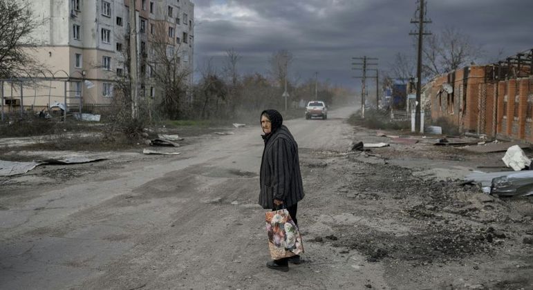 Mulher caminha pelas  ruas devastadas de Kherson, cidade ocupada pela Rússia