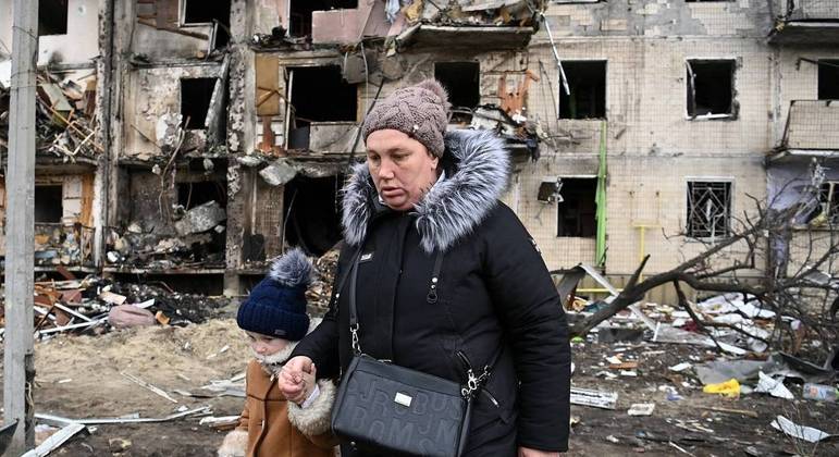 Mulher e criança deixam Kiev após bombardeios
