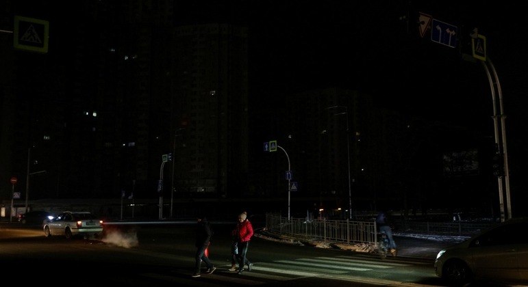 Pessoas atravessam uma rua sem eletricidade em Kiev