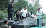 O líder da Coreia do Norte, Kim Jong-un (ao centro), em cima de umveículo blindado multiuso, após uma visita a uma importante fábrica de muniçõesem local não revelado na Coreia do Norte