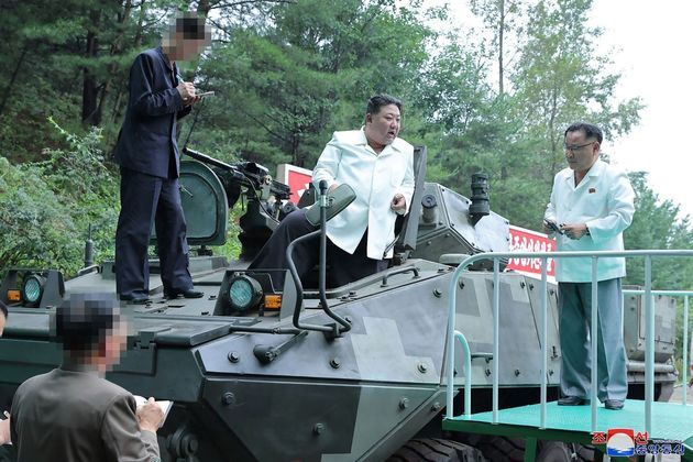 O líder da Coreia do Norte, Kim Jong-un (ao centro), em cima de umveículo blindado multiuso, após uma visita a uma importante fábrica de muniçõesem local não revelado na Coreia do Norte