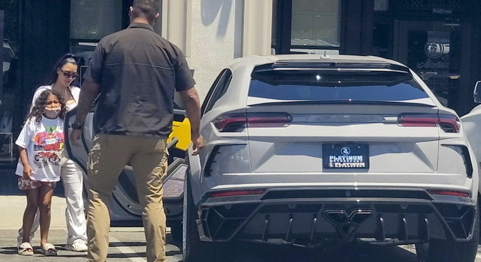Kim Kardashian e a filha saindo de restaurante em um carro de luxo