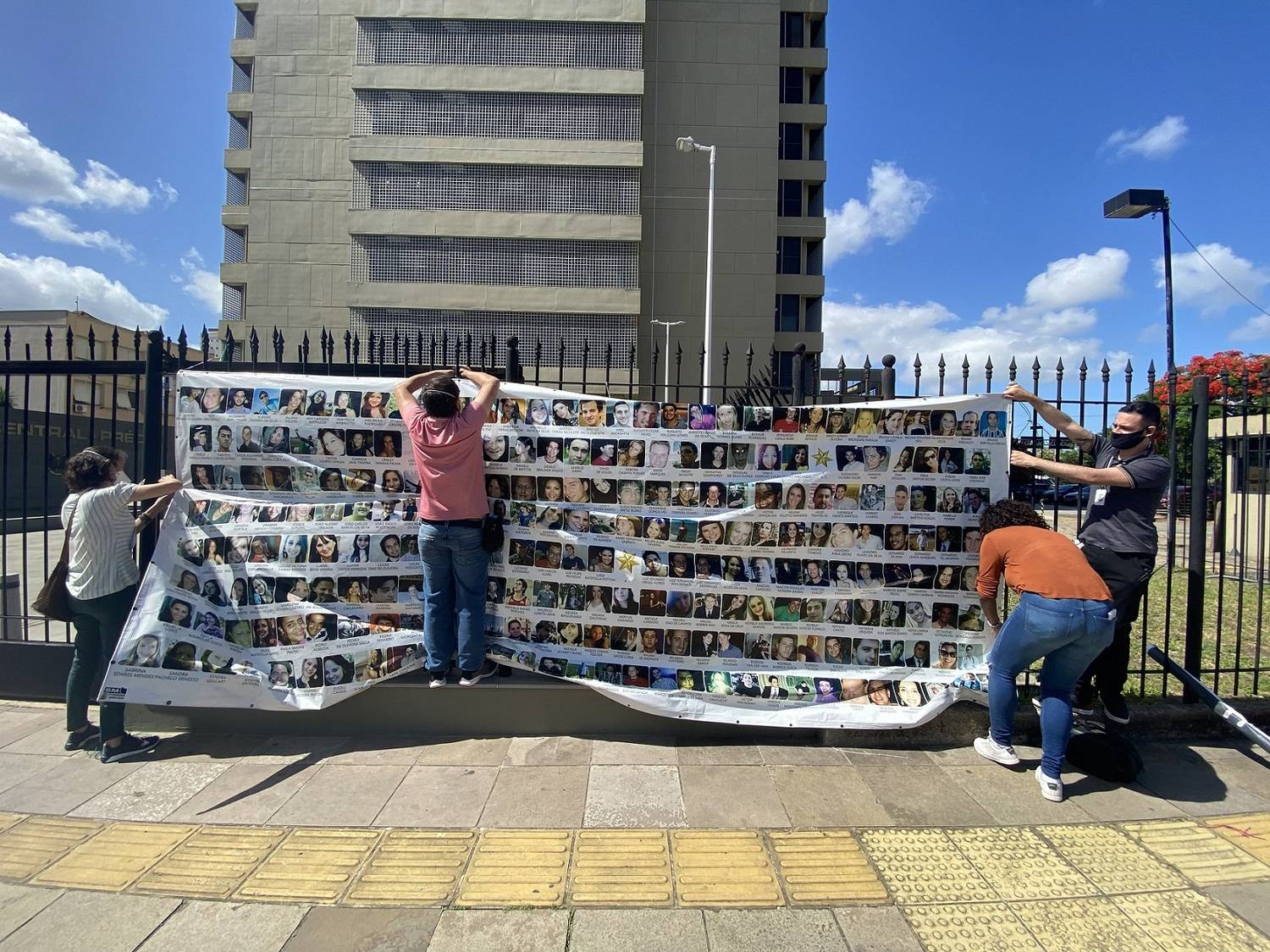 Familiares colocam faixa em homenagem às vítimas da Kiss (Fabíola Perez/R7)