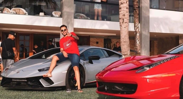 Influenciador digital Klebim aparece em imagem sentado no capô de um carro cinza
