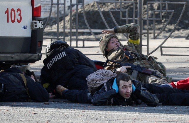 Homens se protegem em Kiev após sirenes tocarem na capital ucraniana para indicar um possível ataque aéreo