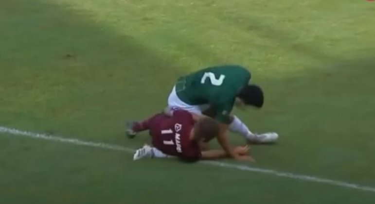 Após bolada no rosto, atacante do Lanús caiu em cima e quebrou perna do defensor adversário
