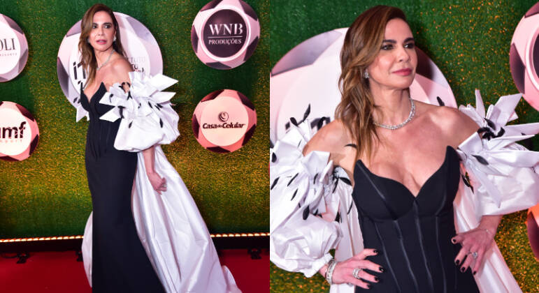 A apresentadora Luciana Gimenez apareceu deslumbrante em um vestido justo preto com capa longa branca e mangas bufantes com aplicação de penas