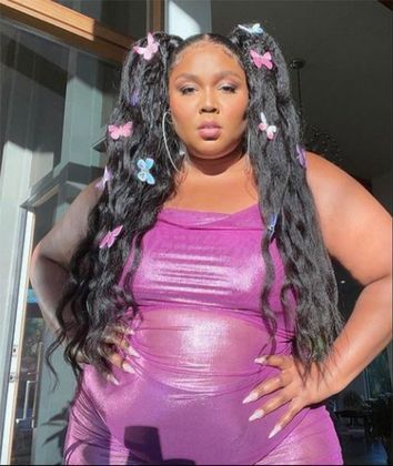 Lizzo dividiu o cabelo e fez dois rabos de cavalo cheios de trancinhas e presilhas de borboleta
