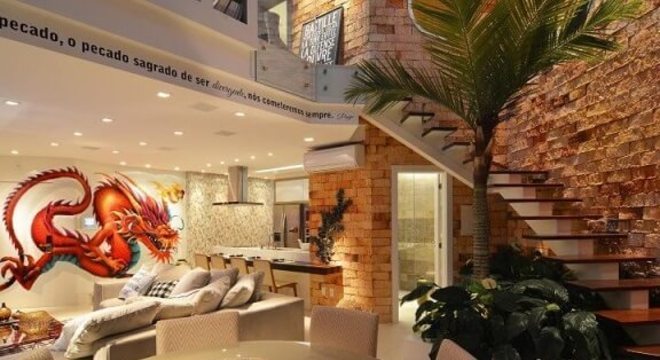 Loft com mezanino e escada de madeira e parede de tijolinho Projeto de Anna e Anderson