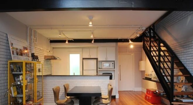 Loft com mezanino e escada de metal preta Projeto de Triplex Arquitetura