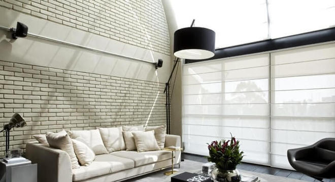 Loft com parede de tijolo pintada de cor clara Projeto de Diego Revollo