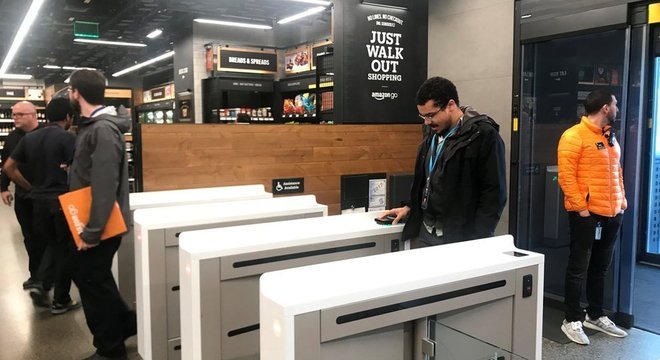 Consumidores entram em uma loja Amazon Go através de um aplicativo em seus smartphones