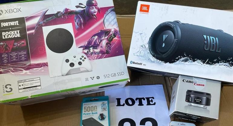 No lote 22, os destaques são: Xbox One, caixa de música JBL e cinco iPhones. O conjunto ainda conta com lenços, carregadores de celular e lente fotográfica. Tudo isso será arrematado por pelo menos R$ 2.500