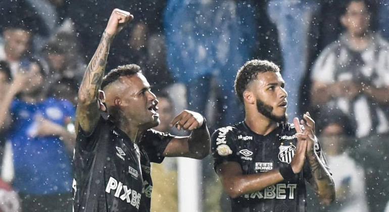 Luan ergue o braço para festejar seu primeiro gol pelo Peixe com os companheiros e a torcida