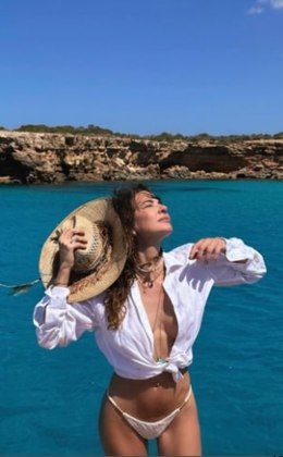 Ainda em Ibiza, ela apareceu com um visual praiano bastante ousado. A apresentadora combinou uma calcinha de biquíni branco com uma camisa social  — peça que ultrapassou as paredes dos escritórios e se tornou um item-chave em diversas ocasiões, seja para um rolê com amigos no bar ou para curtir uma praia, como foi o caso de Luciana. A artista ainda usou um chapéu de palha para completar o look