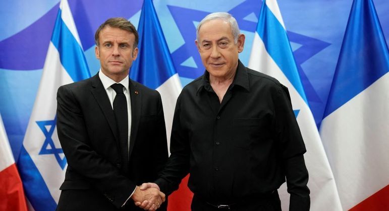 Macron e Netanyahu se cumprimentam durante encontro nesta terça (24), em Israel
