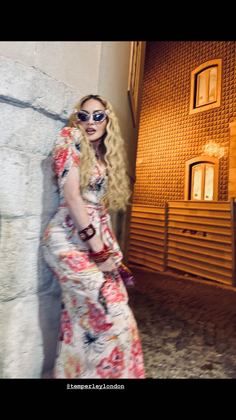 Madonna compartilhou uma série de fotos dela nos stories do Instagram usando um vestido florido, pulseiras vermelhas no braço e óculos escuros, durante a celebração de ontem