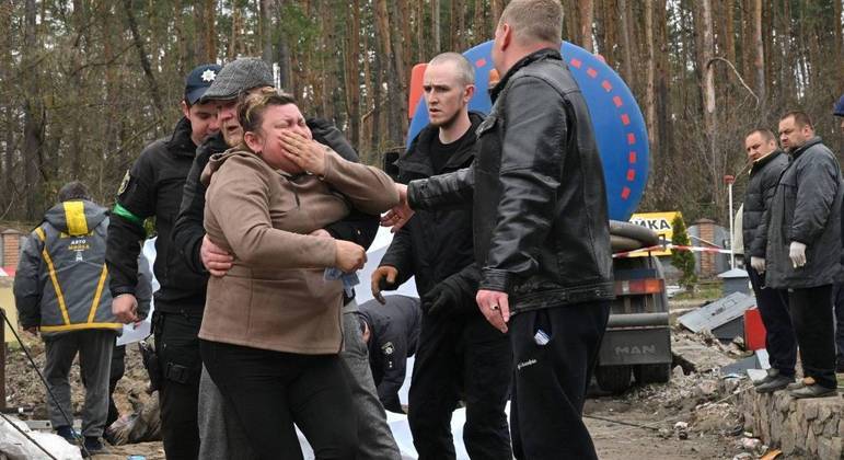 Uma mãe ucraniana reage depois que o corpo de seu filho foi descoberto perto de Kiev