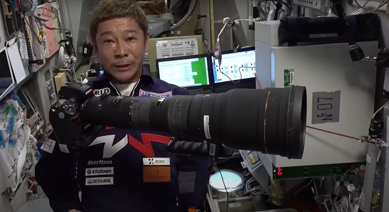 Yusaku Maezawa usa uma câmera com lente teleobjetiva para tirar fotos da Terra
