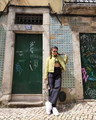 Durante uma viagem para Lisboa, em Portugal, a apresentadora apostou em um visual mais urbano ao combinar calça e tênis com top e jaqueta verdes. 