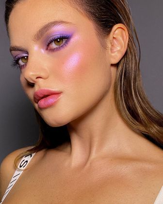 Com uma pegada mais futurista e que combina com eventos noturnos, aposte em tons holográficos da cor, espalhando inclusive abaixo das sobrancelhas e nas maçãs do rosto. Vale depositar uma pitada nos lábios também