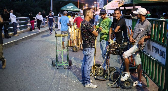 Muitos venezuelanos cruzam a fronteira durante o dia, para ganhar dinheiro fazendo bicos, e retornam de noite ao país. Esse grupo de jovens ganha trocados carregando as malas de quem cruza a ponte