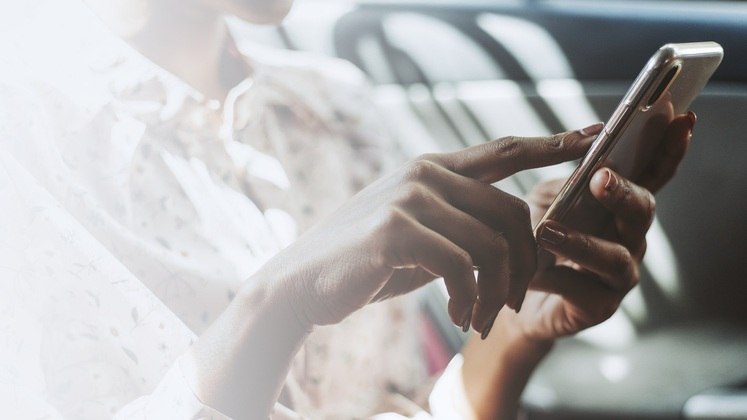 Mão de mulher digitando em um telefone celular. Freepik/rawpixel