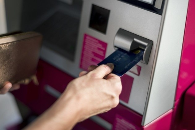 Mão masculina insere cartão bancário em caixa eletrônico. Rawpixel / Freepik
