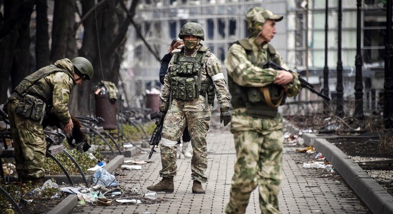 Soldados russos caminham pelo centro de Mariupol