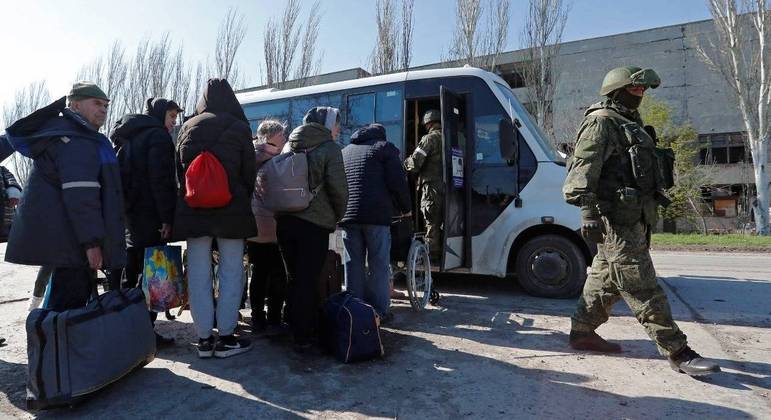 Ucranianos entram em um ônibus para deixar a cidade de Mariupol