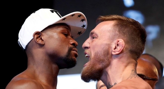 McGregor (à dir.) encara Mayweather antes de sua estreia no boxe