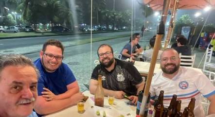 Daniel (de camisa azul) e seus colegas em quiosque na Barra da Tijuca momentos antes do ataque
