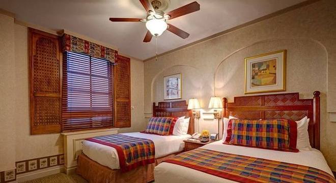 melhor travesseiro - cama com cabeceira de madeira e ventilador de teto 