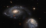 Duas galáxias, que formam uma dupla chamada Arp-Madore 608-333, aparecem lado a lado nessa captura do Hubble. 'Embora pareçam serenos e imperturbáveis, as duas estão sutilmente distorcendo um ao outro através de uma interação gravitacional mútua que está perturbando e distorcendo ambas as galáxias', descreve o site da ESA
