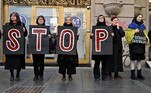 Membros da organização antiguerra 'Mulheres de Preto' seguram cartazes durante um protesto contra a invasão russa na Ucrânia, em Belgrado, capital da Sérvia
