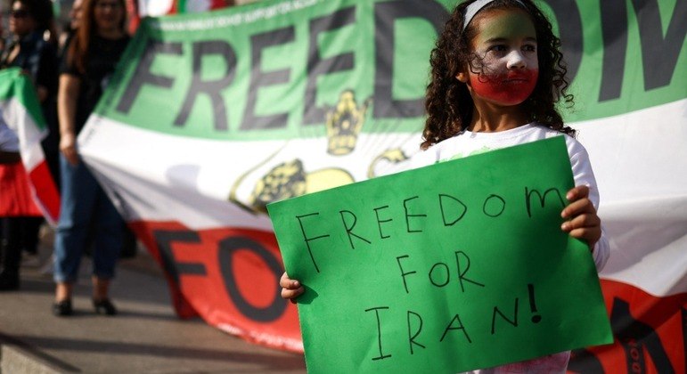 Menina segura cartaz coma a frase 'liberdade para o Irã' em manifestação em Londres
