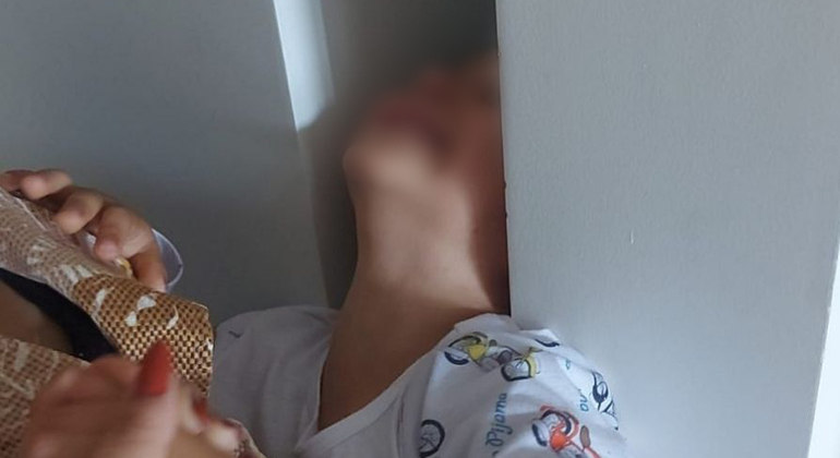 Menino prende a cabeça em parede de casa