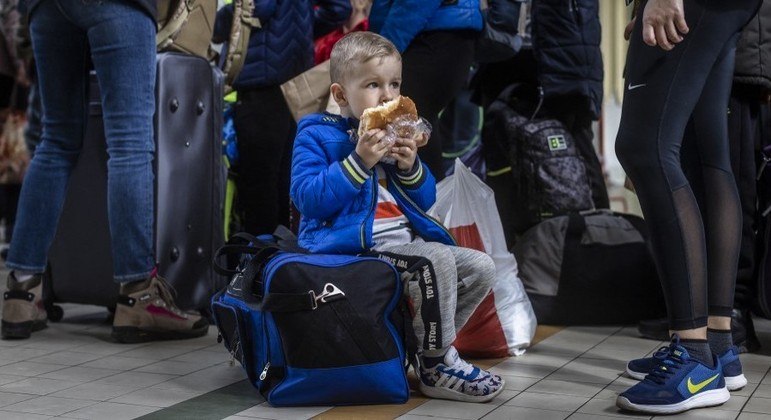 Menino  ucraniano come um pão em estação ferroviária em Przemysl, no leste da Polônia