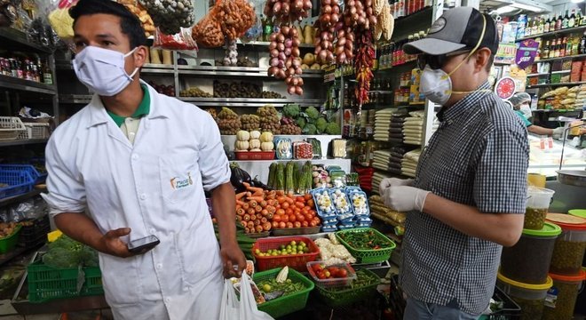 Clientes usando máscaras em mercado em Lima