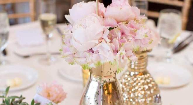 mesa de ano novo decorada com arranjo de rosas em vasos dourados