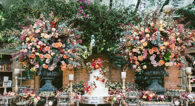 Mesa de bolo de casamento boho chic com arranjos coloridos