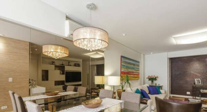 Mesa de jantar de vidro com lustre moderno na decoração