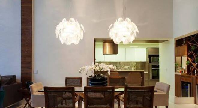 Mesa de jantar de vidro com lustres na decoração