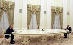 Grandes mesas foram usadas para garantir o distanciamento necessário entre o presidente russo e seus interlocutores