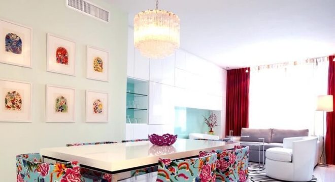 Mesa retangular com tampo branca se harmoniza com as estampas coloridas das cadeias