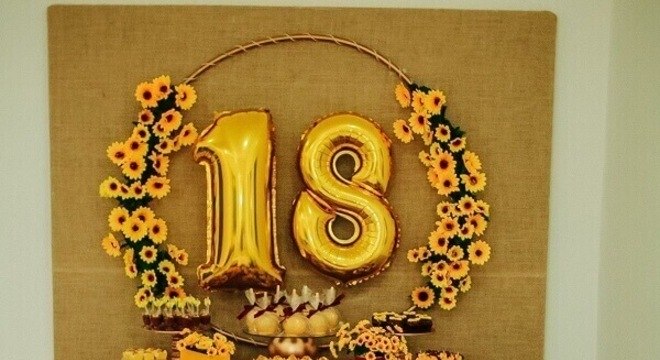 Mesa simples para festa tema girassol com mesa de madeira e flor de samambaia