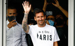 Messi acena ao chegar ao aeroporto de Paris para assinar com o PSG