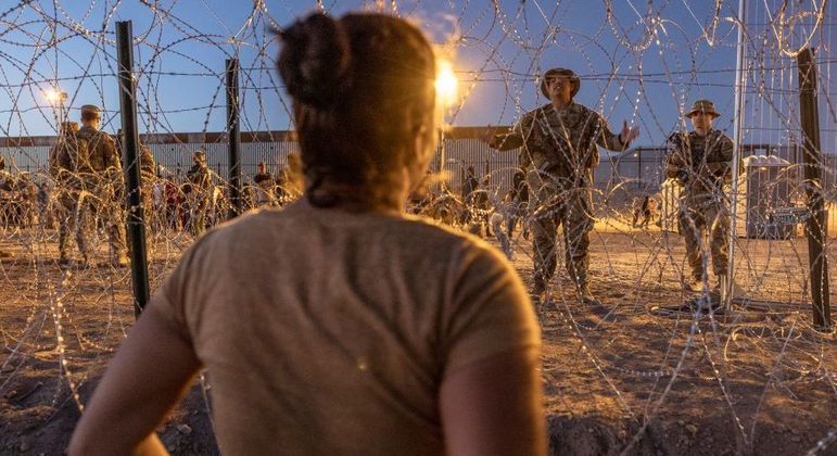 Na fronteira do México com o Texas, soldados americanos barram a entrada de uma migrante