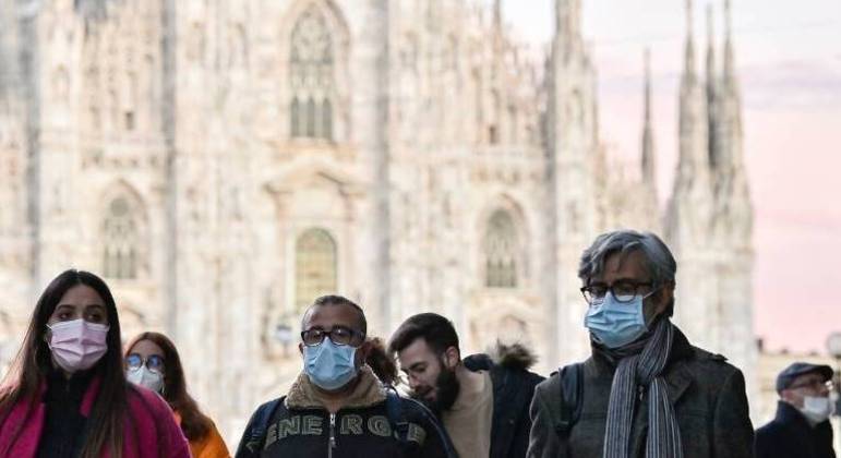 Pedestres usam máscara em meio à pandemia de Covid-19 em Milão, na Itália